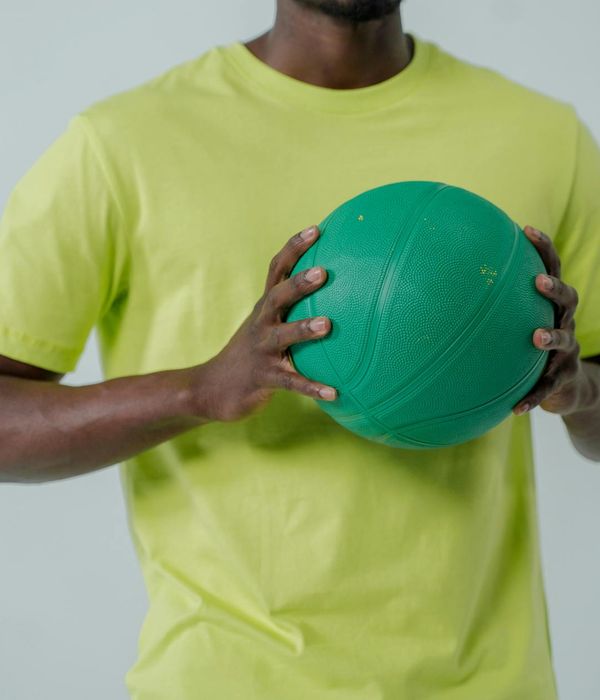 Person engaged in a fluid motion exercise in a bright, minimalist space.